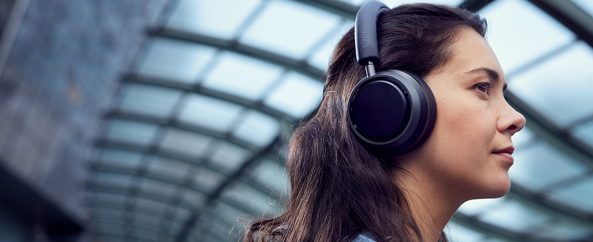  Philips L4 kulaklık kullanarak seyahatte m&uuml;zik keyfi yapan kadın